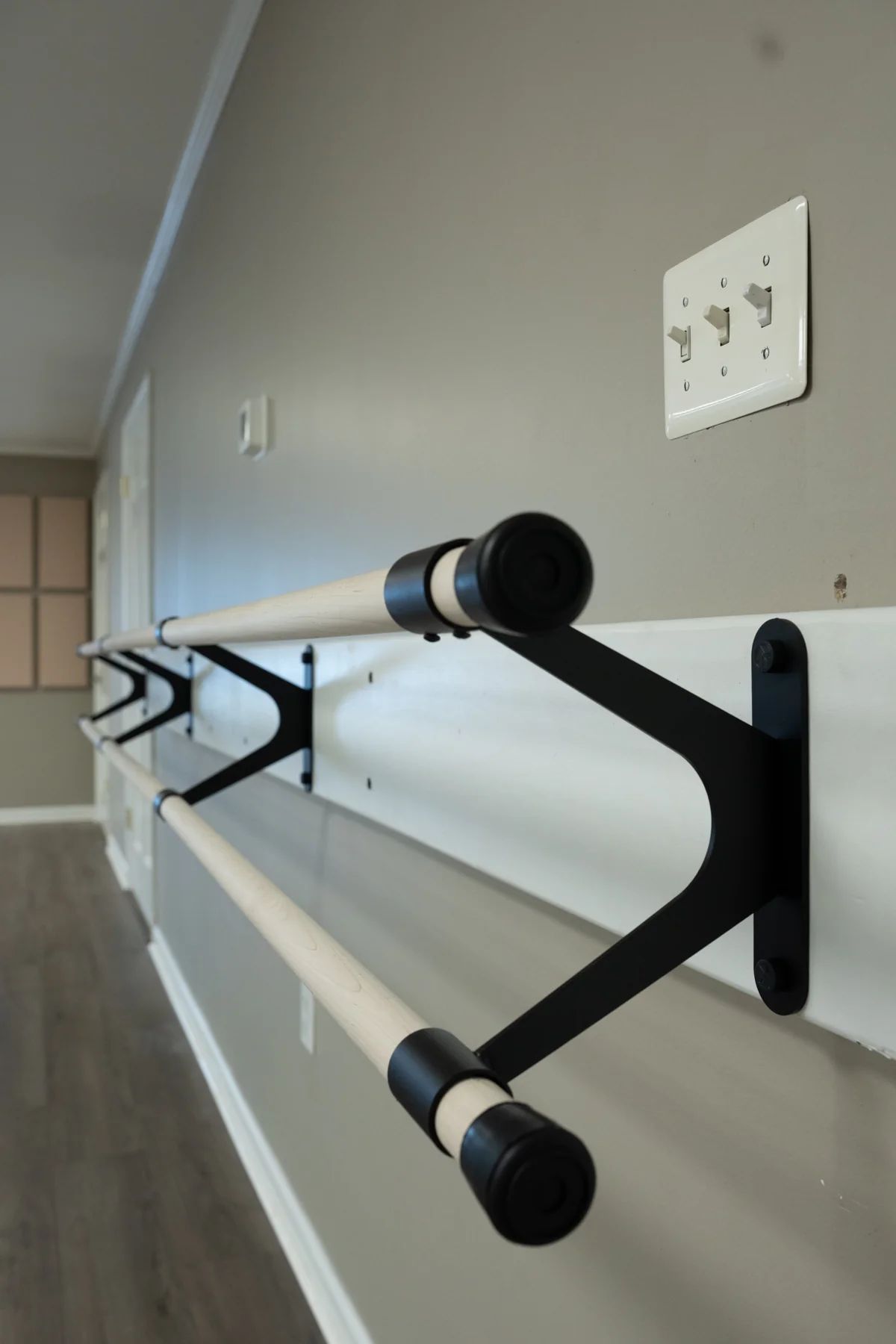A close view of a ballet barre and its wall bracket