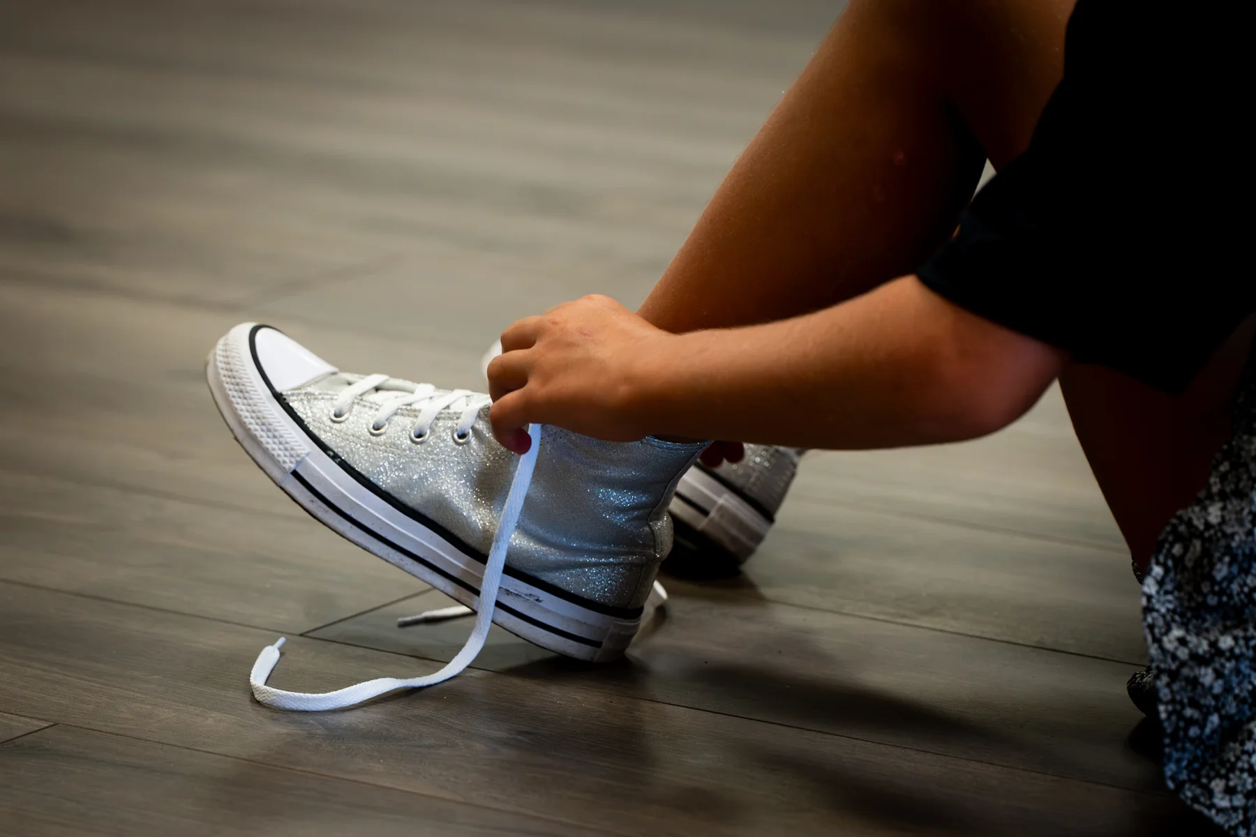 Hands tying the laces on a tap shoe